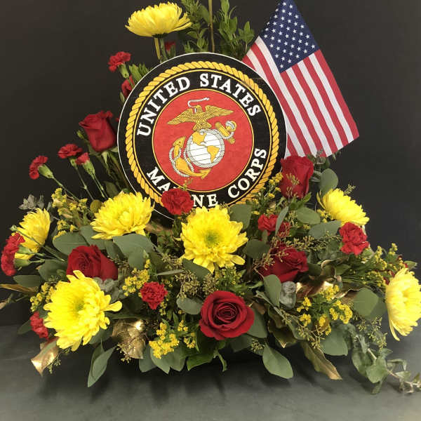 Floral tribute with red roses, yellow mums, and a U.S. Marine Corps emblem
