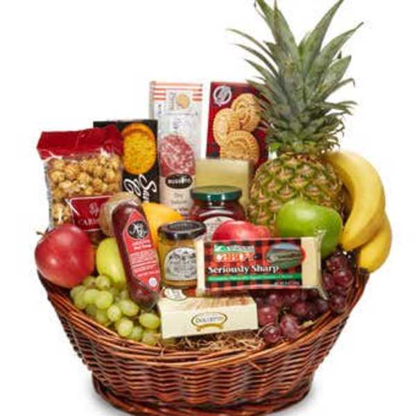 Fruit and snack gift basket with a pineapple, bananas, grapes, and packaged treats