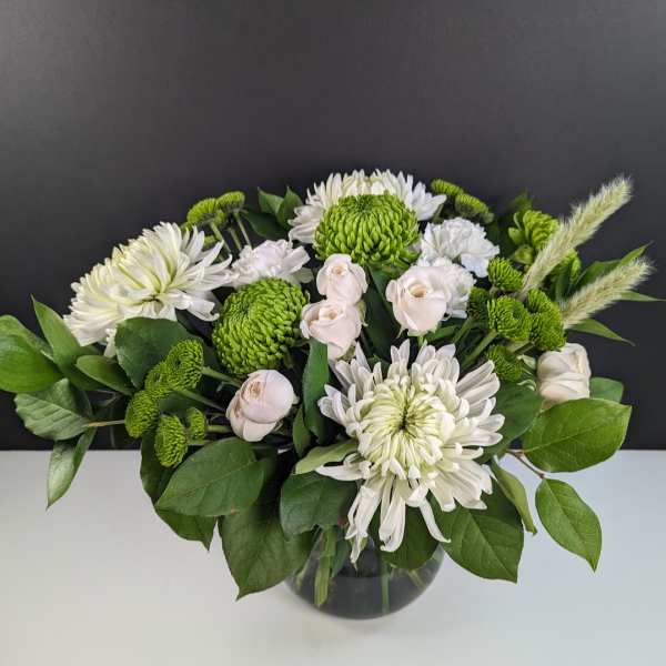 White and green floral arrangement in a glass vase