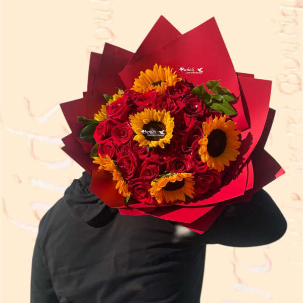 Bouquet of red roses and yellow sunflowers wrapped in red paper