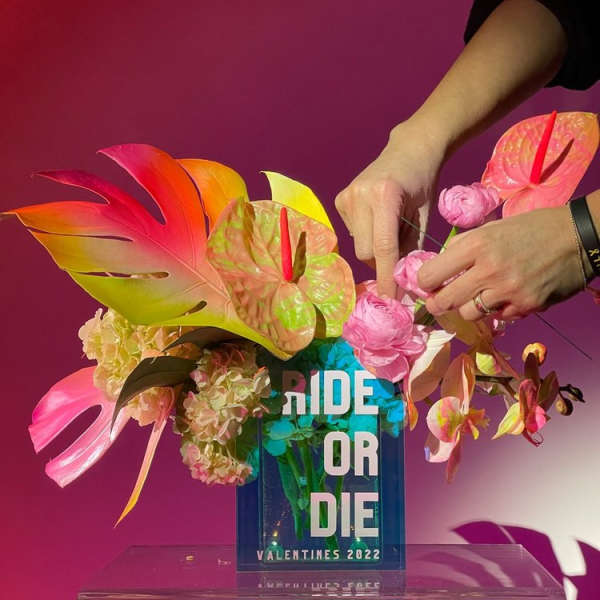 Tropical floral arrangement with pink blooms in a clear vase