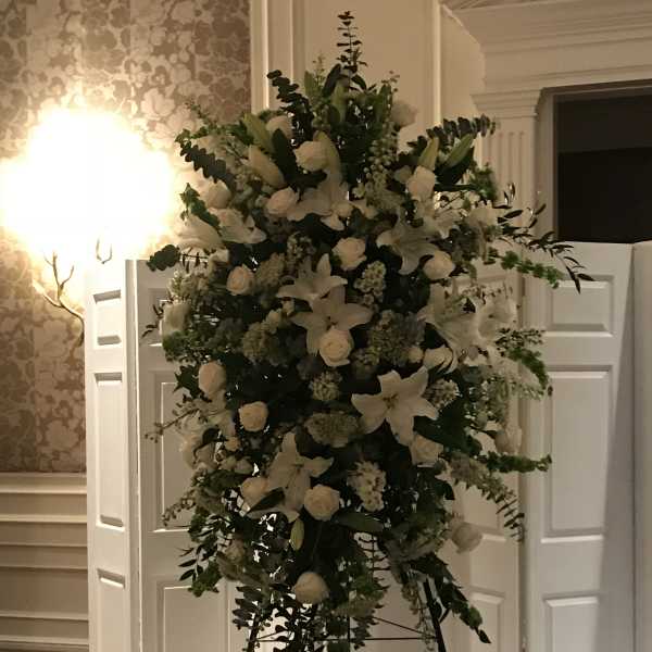Large white floral standing arrangement on an easel