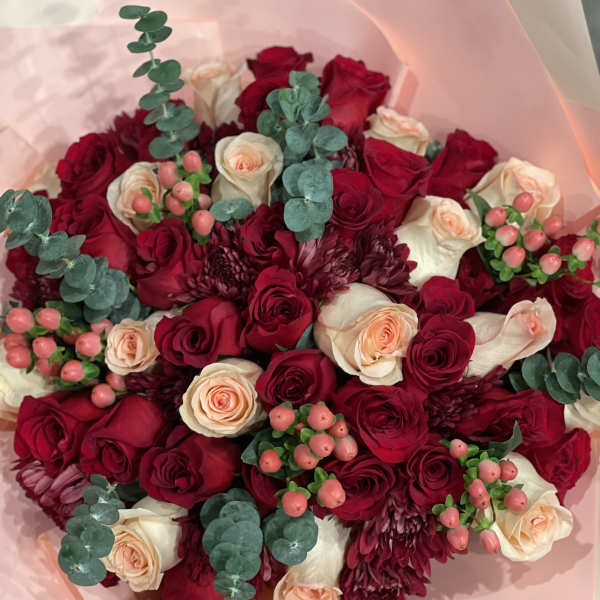 Bouquet of red and cream roses with burgundy blooms and eucalyptus