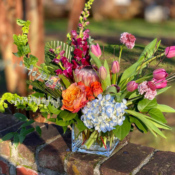 Colorful mixed bouquet in a clear square vase