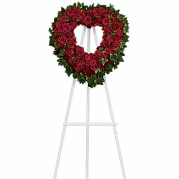 Heart-shaped red rose wreath on a white easel