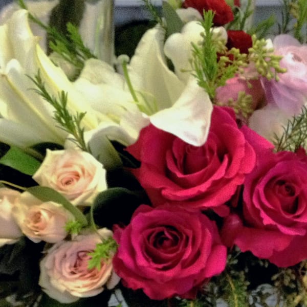 Bouquet of pink roses and white calla lilies with small accent flowers