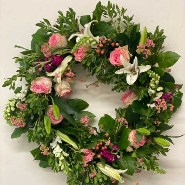 Circular floral wreath with pink roses and white lilies