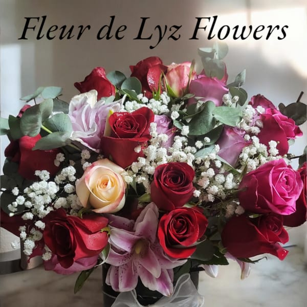 Bouquet of red and pink roses with lilies in a black vase