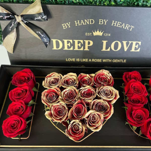 Heart-shaped rose box with red and cream roses in a black gift box