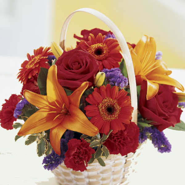 Basket of red and orange flowers with purple accents