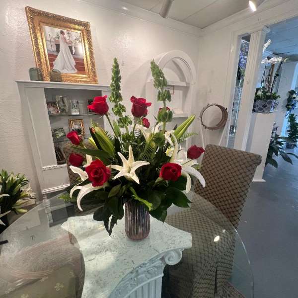Red roses and white lilies arranged in a glass vase
