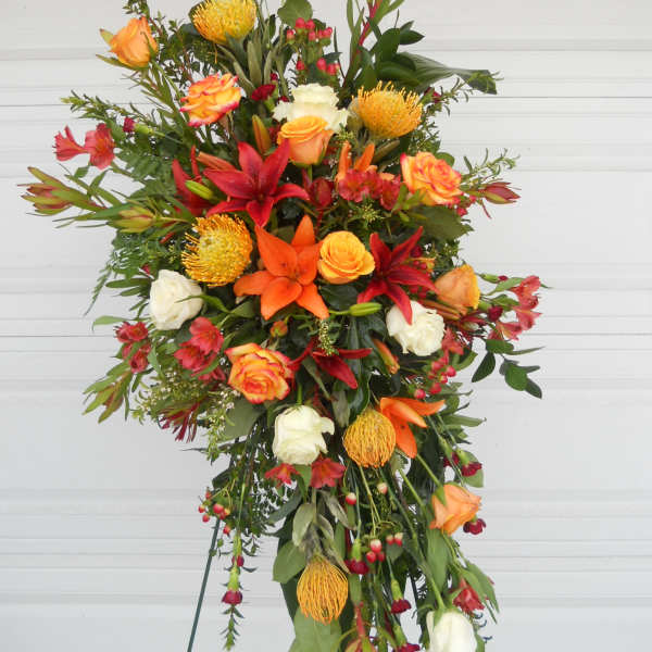 Tall standing floral spray with orange, red, and white blooms