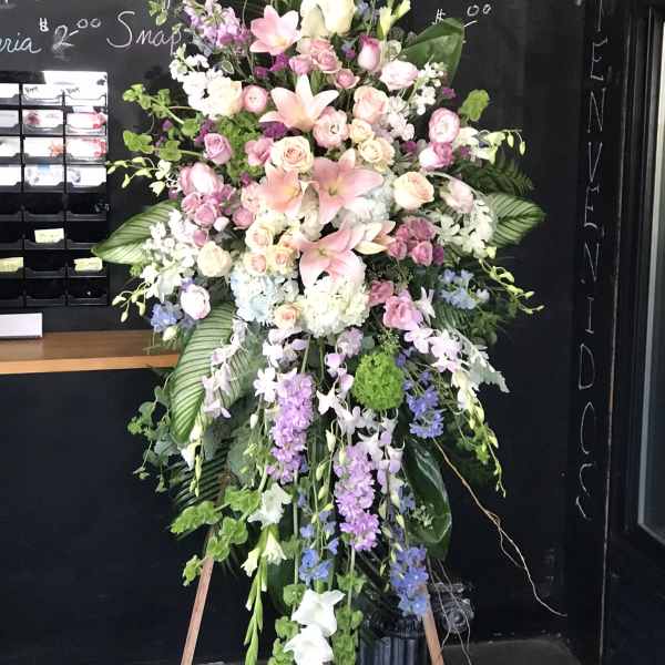 Large standing floral spray with pink lilies, roses, and purple flowers