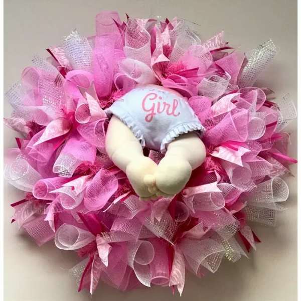 Pink decorative wreath with a baby doll in the center