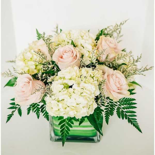 Bouquet of pale pink roses and white hydrangeas in a glass vase