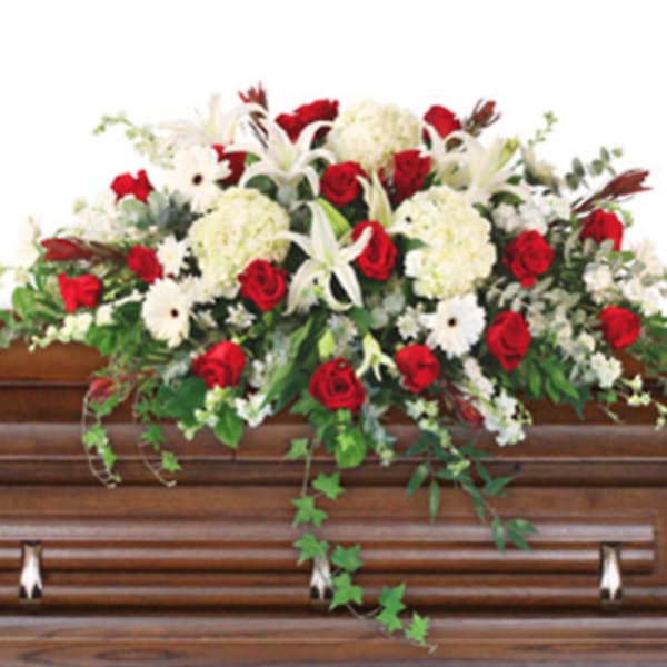 Red and white floral spray on a wooden casket