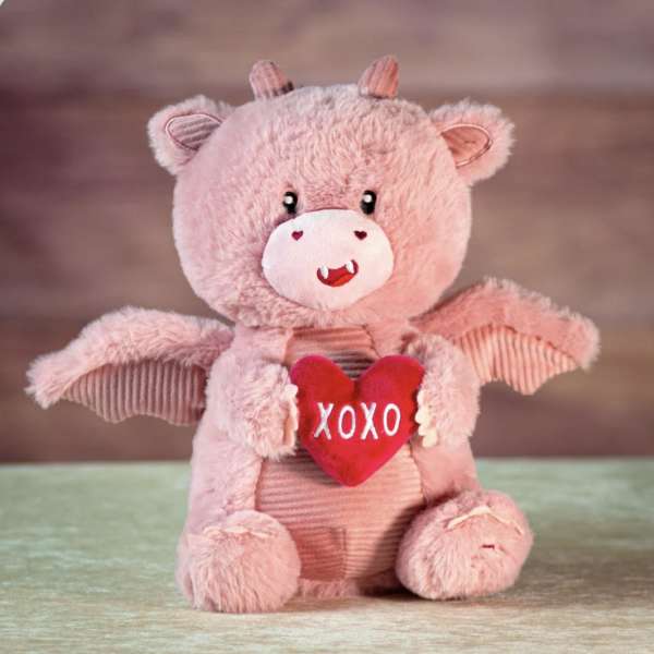 Pink plush teddy bear holding a red heart that says XOXO