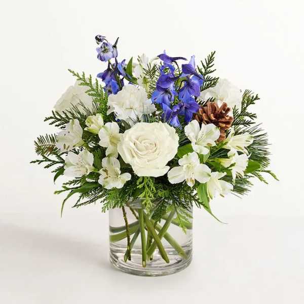 White and blue floral arrangement in a clear glass vase