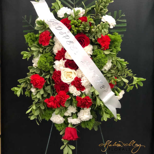 Standing floral spray with red and white flowers and a white ribbon