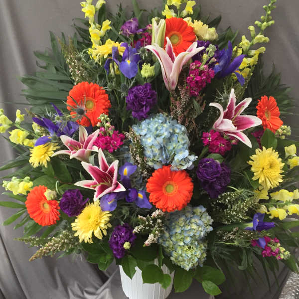 Colorful mixed flower arrangement in a white vase