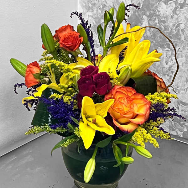 Colorful bouquet of roses and lilies in a glass vase