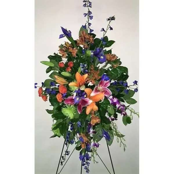 Tall floral standing spray with orange, purple, and pink blooms