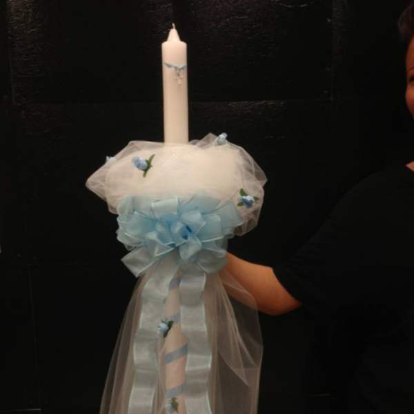 Decorated white candle with pale blue ribbon and tulle