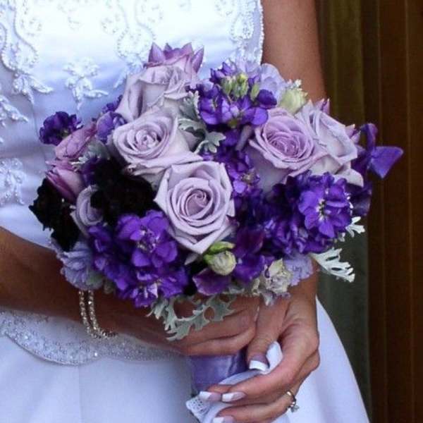 Bride holding a bouquet of lavender roses and purple flowers