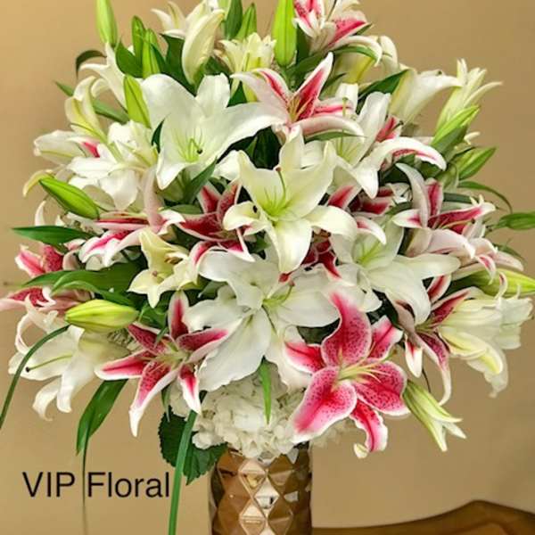 Bouquet of white and pink lilies in a gold vase