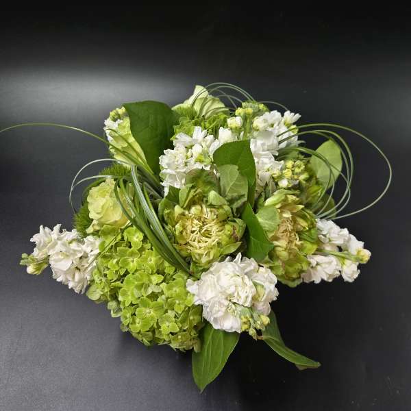 Green and white floral arrangement with hydrangeas and white blooms