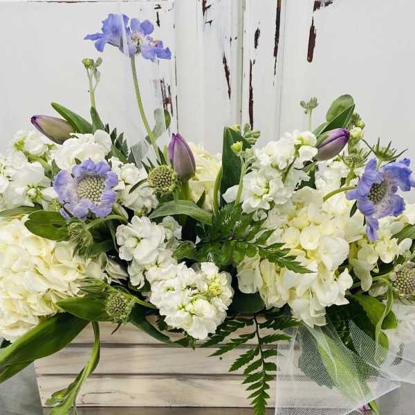 White and lavender floral arrangement in a wooden box