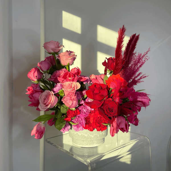 Pink and red rose arrangement in a white vase