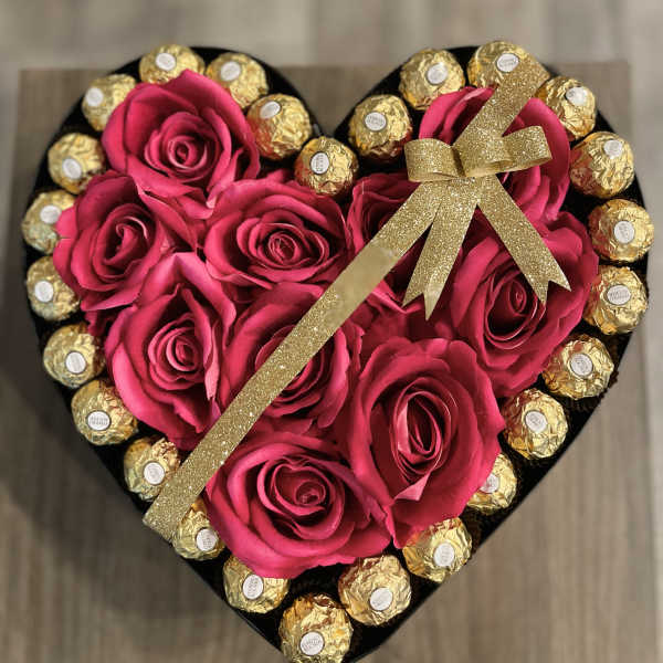 Heart-shaped box with pink roses and gold-wrapped chocolates