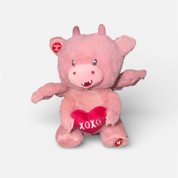 Pink plush pig holding a heart with "XOXO"