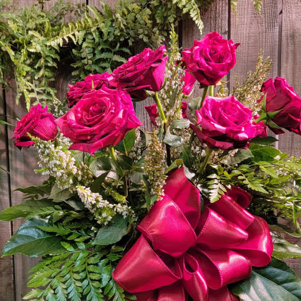 Pink roses in a glass vase with a large satin bow