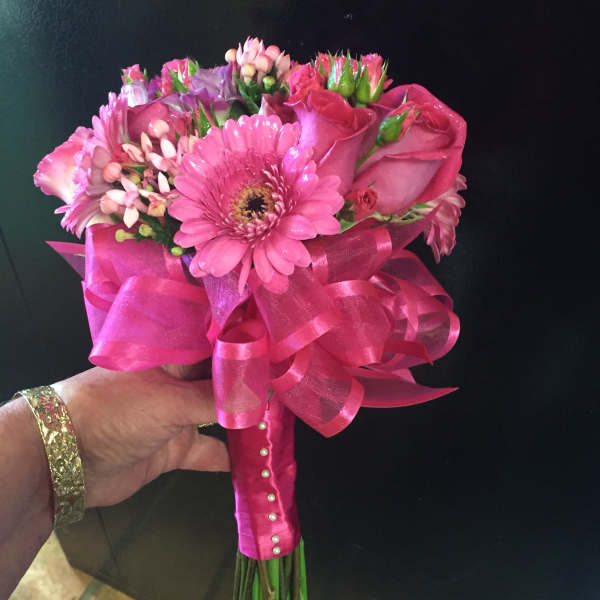 Pink bouquet with roses and gerbera daisies wrapped in bright ribbon