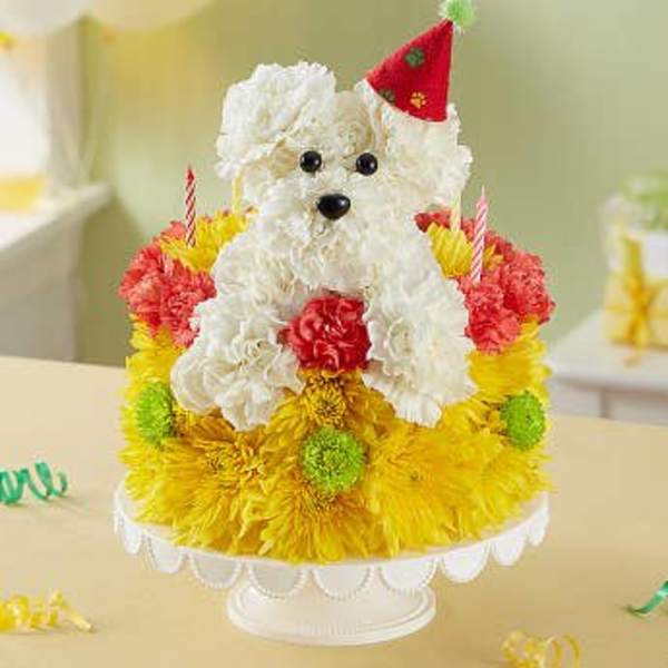 White teddy bear on a colorful flower-covered cake stand