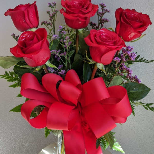 Bouquet of red roses with a large red ribbon in a glass vase