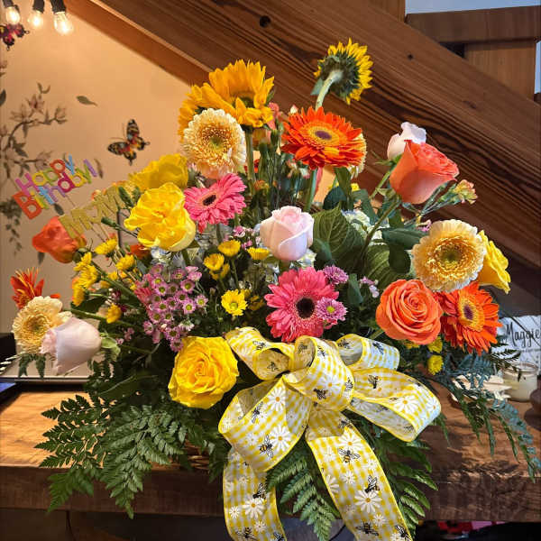 Colorful mixed flower arrangement with a birthday sign and yellow ribbon