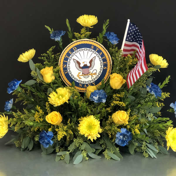 Yellow and blue floral tribute with a U.S. Navy emblem and American flag