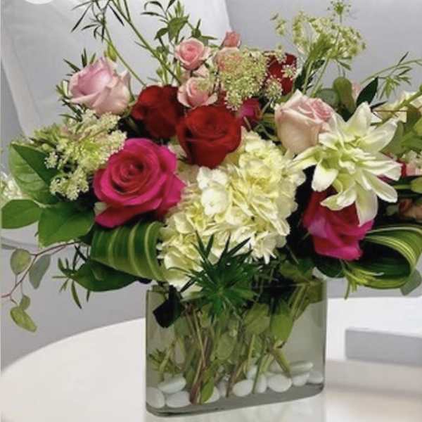 Mixed roses and white blooms in a square glass vase