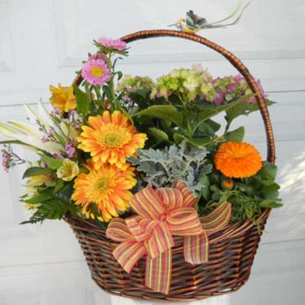 Basket of mixed flowers with a striped ribbon bow