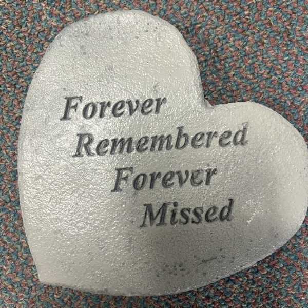 White heart-shaped memorial stone with engraved text