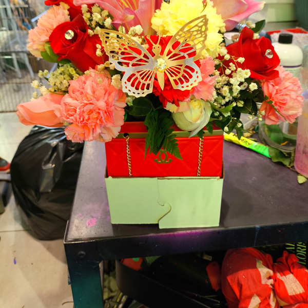 Bright mixed bouquet with roses, lilies, and carnations in a red box