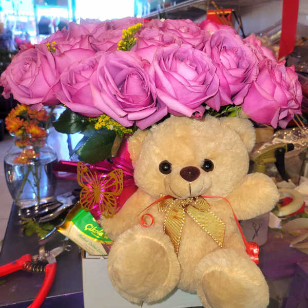 Pink rose bouquet with a teddy bear and ribbon