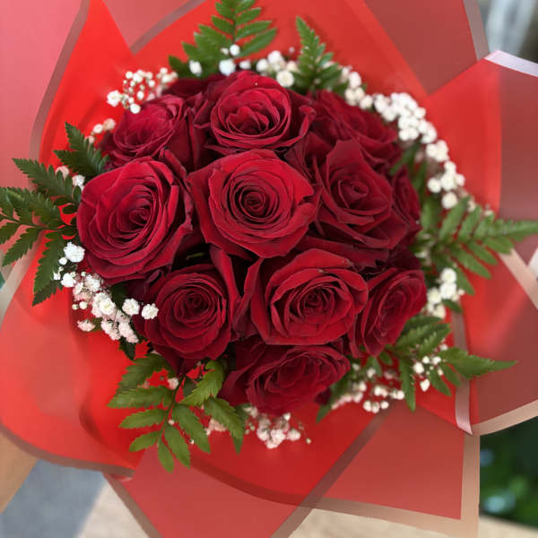 Bouquet of red roses with white baby's breath in red wrap