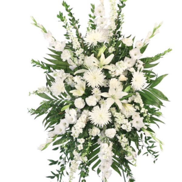 White funeral spray with lilies and chrysanthemums on a standing easel