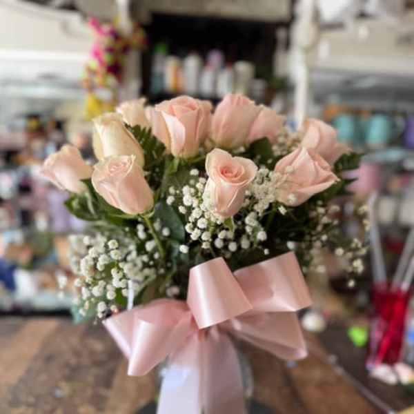 Bouquet of pale pink roses with baby's breath and a pink ribbon