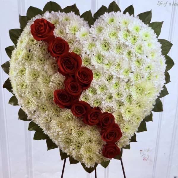 Heart-shaped floral tribute with white chrysanthemums and red roses