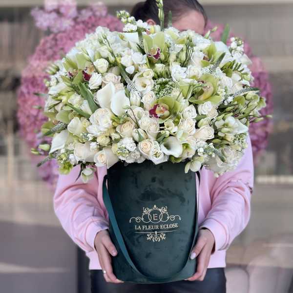 Large white and pale green floral arrangement in a dark green box